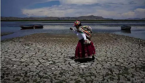  ?? ?? Une femme marche sur une partie asséchée du lac Titicaca à Coata, au Pérou, le 29 novembre 2023, pendant une vague de chaleur.