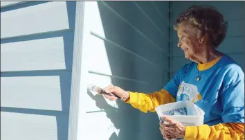  ??  ?? Volunteers Sandy Allgood, (above) from First Congregati­onal Church, and Jay Clover, from First Church of the Nazarene, paint Powell’s home during the Burlington/West Burlington Paint-A-Thon.