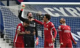  ??  ?? Alisson points to the sky in delight after the goalkeeper’s astonishin­g winner for Liverpool. Photograph: Rui Vieira/Reuters