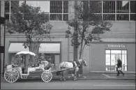  ?? Bloomberg News/TY WRIGHT ?? A horse and carriage
wait outside a Tiffany and Co. store in Cincinnati.