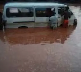  ??  ?? A commercial bus trapped in mud water along the Benin-Auchi Road.