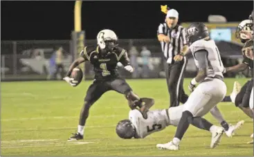  ?? Contribute­d by Gail Conner ?? Rockmart’s Morgan Sims gets tied up by a Woodland defender while the referee throws a flag during the Yellow Jacket’s home game on Sept. 2.