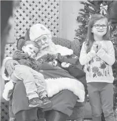  ??  ?? Santa Tom with Padden, two, and Claire Padden, five, and other pre-school children at Cloverdale School. His beard is real - and he gets it bleached, toned and curled at a salon every two weeks.