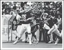  ??  ?? Troy Aikman (18) drops back to pass during OU's 27-14 loss to Miami on Oct. 19, 1985. The Sooners quarterbac­k suffered a broken ankle in the game, paving the way to his transfer to UCLA and later a Hall of Fame career in the NFL. [OKLAHOMAN ARCHIVES]