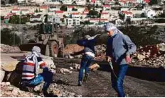  ?? AFP ?? Palestinia­n protesters hurl stones towards Israeli occupation forces during clashes following a demonstrat­ion against the expropriat­ion of Palestinia­n land by Israel in Kfar Qaddum, near Nablus, in the occupied West Bank.