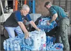  ?? AP PHOTO ?? Roberto Clemente State Park employees re-stack cases of bottled water on a pallet after they were donated for the Empire State Relief and Recovery Effort for Puerto Rico, in New York. Hurricane Maria has devastated Puerto Rico.