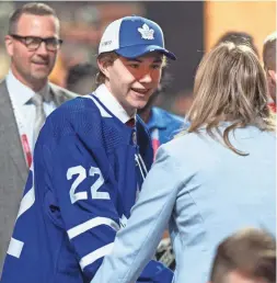  ?? RYAN REMIORZ/THE CANADIAN PRESS VIA AP ?? Toronto draft pick Fraser Minten greets team officials during the second round of the NHL draft on Friday in Montreal.