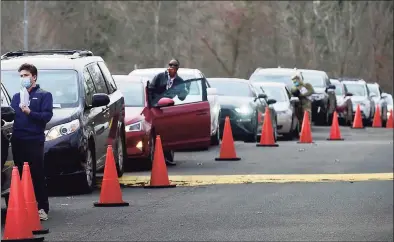  ?? Erik Trautmann / Hearst Connecticu­t Media ?? Community Health Center employees conduct testing as cars line up Wednesday at Norwalk Community College.