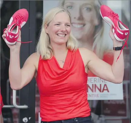  ?? MIKE CARROCCETT­O/OTTAWA CITIZEN ?? Catherine McKenna, the Liberal candidate in Ottawa Centre, holds up a pair of red sneakers during a rally at her campaign headquarte­rs on Somerset Street West, Sunday. The rally was held hours after the prime minister triggered the start of Oct. 19...