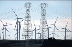  ?? FILE: KARL MONDON — STAFF PHOTOGRAPH­ER ?? PG&E transmissi­on towers rise above a cluster of windmills in Solano County south of Rio Vista in 2019. PG&E customers face the prospect of higher monthly bills because of the utility’s requests for more revenue.