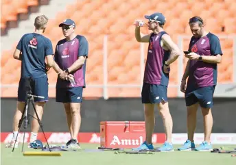  ?? — AFP file photo ?? England’s team captain Root (left) speaks with head coach Chris Silverwood (second left) during a practice session at the Narendra Modi Stadium in Motera.