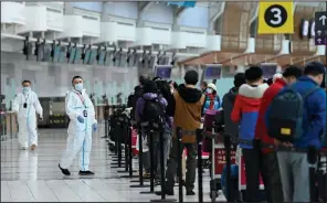  ?? (AP/The Canadian Press/Nathan Denette) ?? People line up Wednesday to board an internatio­nal flight at the airport in Toronto. Canadian Prime Minister Justin Trudeau closed Canada’s internatio­nal borders to nonessenti­al travel in March.