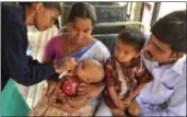  ??  ?? Indian medical volunteers administer a dose of oral vaccine to a child at a bus terminal during in February 2012a national immunizati­on program in Hyderabad.