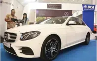  ?? FRIZAL/JAWA POS ?? SENSUAL: Elizabeth Hidajatno (kanan) dan Sales Consultant Donny di samping Mercedes-Benz E300 CKD 2017 New di Surabaya kemarin.