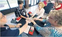  ?? STEPHEN M. DOWELL/STAFF PHOTOGRAPH­ER ?? From left, bridge players Souheil Moossly, Karin Thomas, Phyllis Englander and Mary Ellen Kammert reach for cards during a recent match.