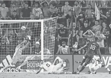  ?? SAM NAVARR/USA TODAY SPORTS ?? Orlando City forward Daryl Dike scores a goal against Columbus Crew goalkeeper Eloy Room in the 26th minute at Orlando City Stadium.