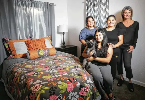  ?? Melissa Phillip photos / Houston Chronicle ?? LeTricia Wilbanks, right, helped the Nietos — Wendy, from left, Ashley with her dog, Vivi, and their mother Anel — replace furniture damaged by floodwater­s.