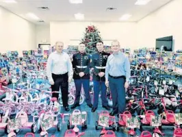  ?? CURRENT BUILDERS ?? Mike Taylor, president of Current Builders, Marines from Toys for Tots, and Chip Reid, CEO of Current Builders, with bikes and toys that were given to children as part of Current Builders’ end-of-year giving campaign.