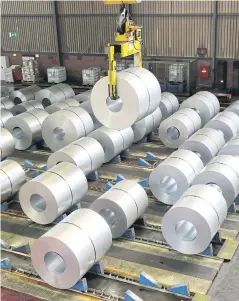  ?? REUTERS ?? A crane operator lifts up a finished steel coil at the storage and distributi­on facility of Thyssenkru­pp AG in Duisburg, Germany.