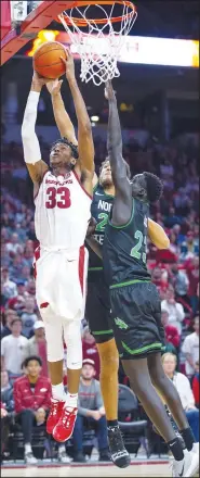  ?? Special to NWA Democrat Gazette/DAVID BEACH ?? Arkansas Senior Jimmy Whitt Jr. (33) goes up strong for the basket Tuesday night with University of North Texas’ Deng Geu (23) trying to block the shot from behind at Bud Walton Arena in Fayettevil­le