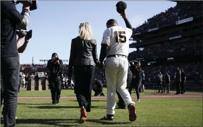  ?? NHAT V. MEYER STAFF PHOTOGRAPH­ER ?? San Francisco Giants manager Bruce Bochy and his wife, Kim, walk onto the field for a postgame ceremony honoring him at Oracle Park in San Francisco on Sunday.