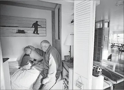  ?? [LEILA NAVIDI/MINNEAPOLI­S STAR TRIBUNE] ?? Al Hermansen plays with his 2-year-old grandson, Matthew, in the tiny cupboard bedroom Hermansen built in his home in Excelsior, Minn.