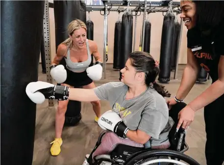  ?? Photos by Melissa Phillip / Staff photograph­er ?? Juliet Porras, left, encourages her daughter, Elena Porras, 15, during a workout session with personal trainer Danielle Henley at Life Time City Centre.