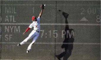  ?? NICK WASS — THE ASSOCIATED PRESS ?? Washington center fielder Michael Taylor leaps for but misses a double by Cincinnati’s Scooter Gennett during the eighth inning Saturday in Washington. The Nationals won 18-3.