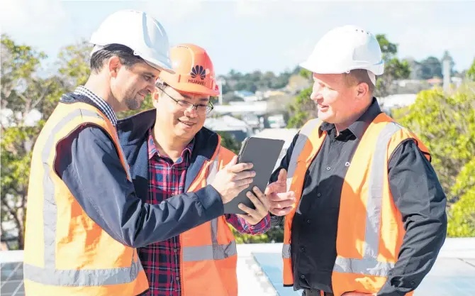  ??  ?? Huawei Managing Director Yanek Fan (centre), Trilect Solar directors Andrew Beckett (left) and Peter McInally (right), assess the efficiency of solar panels using the Huawei FusionSola­r App.