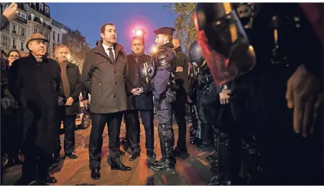  ?? FOTO: AFP ?? Christophe Castaner spricht am Samstagabe­nd auf den Pariser Champs-Elysées mit Polizisten, die bei den Protesten im Einsatz waren.