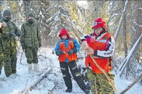  ??  ?? Vanessa Searson, centre, and Tammy Cook-Searson, right, members of the La Ronge Ranger Patrol, teach members of the Canadian Armed Forces how to make a rabbit snare.