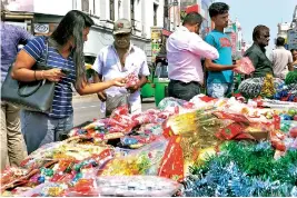  ??  ?? Customers inspect the tinsel and baubles on sale