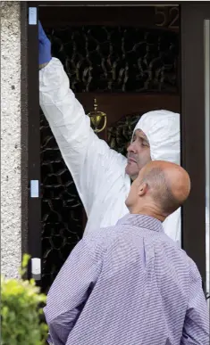  ??  ?? Forensic gardaí examine bullet holes in the doorway of the house at Rathsallag­h Park in Shankill.