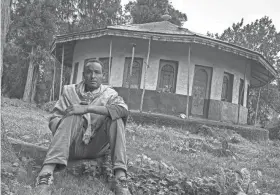  ?? AP ?? Yared Adamu holds an Ethiopian Orthodox cross in the churchyard where residents say more than 50 civilians have been laid to rest in makeshift graves in the village of Chenna Teklehayma­not in the Amhara region of northern Ethiopia. “Many of the innocent civilians here have lost their lives,” he said.