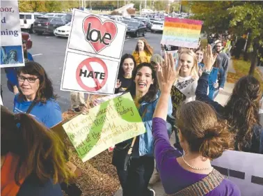  ?? STAFF PHOTO BY ROBIN RUDD ?? Protesters are welcomed as they arrive along East Fourth Street.