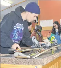  ?? GREG MCNEIL/CAPE BRETON POST ?? Pro shop employee Tyler Kehoe makes some final adjustment­s to a ski during opening day at Ski Ben Eoin on Wednesday.