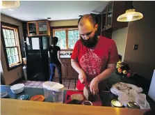  ??  ?? Nate Thames slices freshly baked bread while preparing lunch with his wife Elizabeth after a morning working on their Vermont property.