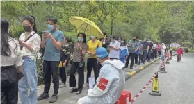  ?? CHINATOPIX VIA AP ?? Residents line up for COVID-19 tests Monday in Guangzhou, China, as the area battles the country’s latest major coronaviru­s surge.