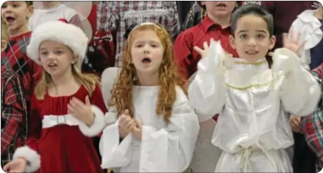  ??  ?? From left, Holy Family students Allison Ortman, Bella McGlinchey and Santino Patitucci perform during the school’s Early Childhood Christmas Extravagan­za.