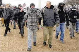  ?? Carolyn Kaster Associated Press ?? PROUD BOYS members Joseph Biggs, front left, and Ethan Nordean, with megaphone, walk toward the U.S. Capitol in Washington before the riot Jan. 6.