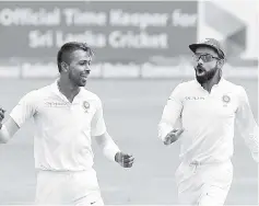  ??  ?? Indian cricketer Hardik Pandya (left) celebrates with his captain Virat Kohli after he dismissed Sri Lankan cricketer Angelo Mathews during the second day of the third and final Test match between Sri Lanka and India at the Pallekele Internatio­nal...