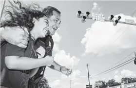  ?? Brett Coomer / Staff photograph­er ?? Police Chief Art Acevedo helps Ava Adams-Marsh cross the updated intersecti­on Monday with its new pedestrian beacon.