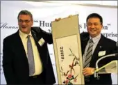  ?? MAY ZHOU / CHINA DAILY ?? He Jian, chairman of the Chinese Council for Promotion of Internatio­nal Trade Hunan Sub-council, presents an embroidere­d painting, a specialty craft of Hunan, to Bob Harvey, president of the Greater Houston Partnershi­p, on Monday.