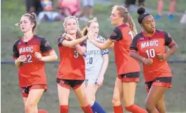  ?? ULYSSES MUÑOZ/BALTIMORE SUN ?? Mercy’s Sydney Feiler, second from left, high-fives Alex Jankowski after scoring a goal during a scrimmage against Calvert Hall on Aug. 25. The Magic enter the season as the top-ranked team in The Baltimore Sun Top 15.