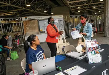  ??  ?? Dekalb County election officials (from left) Nytia Harris, Erin Adam and Lamashia Davis work to spread informatio­n about changes in voter laws and offer free voter IDS at the Chamblee MARTA Station.