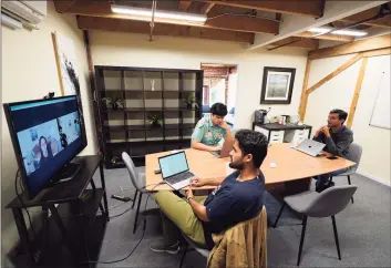  ?? Associated Press ?? RunX CEO Ankur Dahiya, center, takes part in a video meeting with employees JD Palomino, top left, and Nitin Aggarwal, right, at a rented office in San Francisco on Aug. 27. Technology companies like RunX that led the charge into remote work early as the pandemic unfurled, are confrontin­g a new challenge as it winds down: how, when and even whether they should bring their long-isolated employees back to offices that have been designed for teamwork.