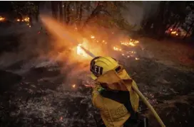  ?? Ap ?? DEVASTATIN­G: A firefighte­r hoses down flames from the Dixie fire in Genesee, Calif., on Aug. 21.