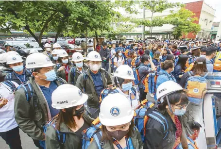  ?? JEssE Bustos ?? Employees of the National Disaster Risk Reduction and Management Council join an earthquake drill outside the Office of Civil Defense at Camp Aguinaldo in Quezon City yesterday.