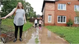  ?? Andrew Teebay ?? ● Faye Tig on her flooded driveway with children Arif, nine, and Ayla, seven