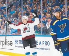  ?? Billy Hurst, The Associated Press ?? Avalanche star Nathan MacKinnon celebrates Thursday night after scoring a first- period goal against Joel Edmundson and the Blues in St. Louis. The Avs return to the Pepsi Center on Friday night, hosting the Nashville Predators.